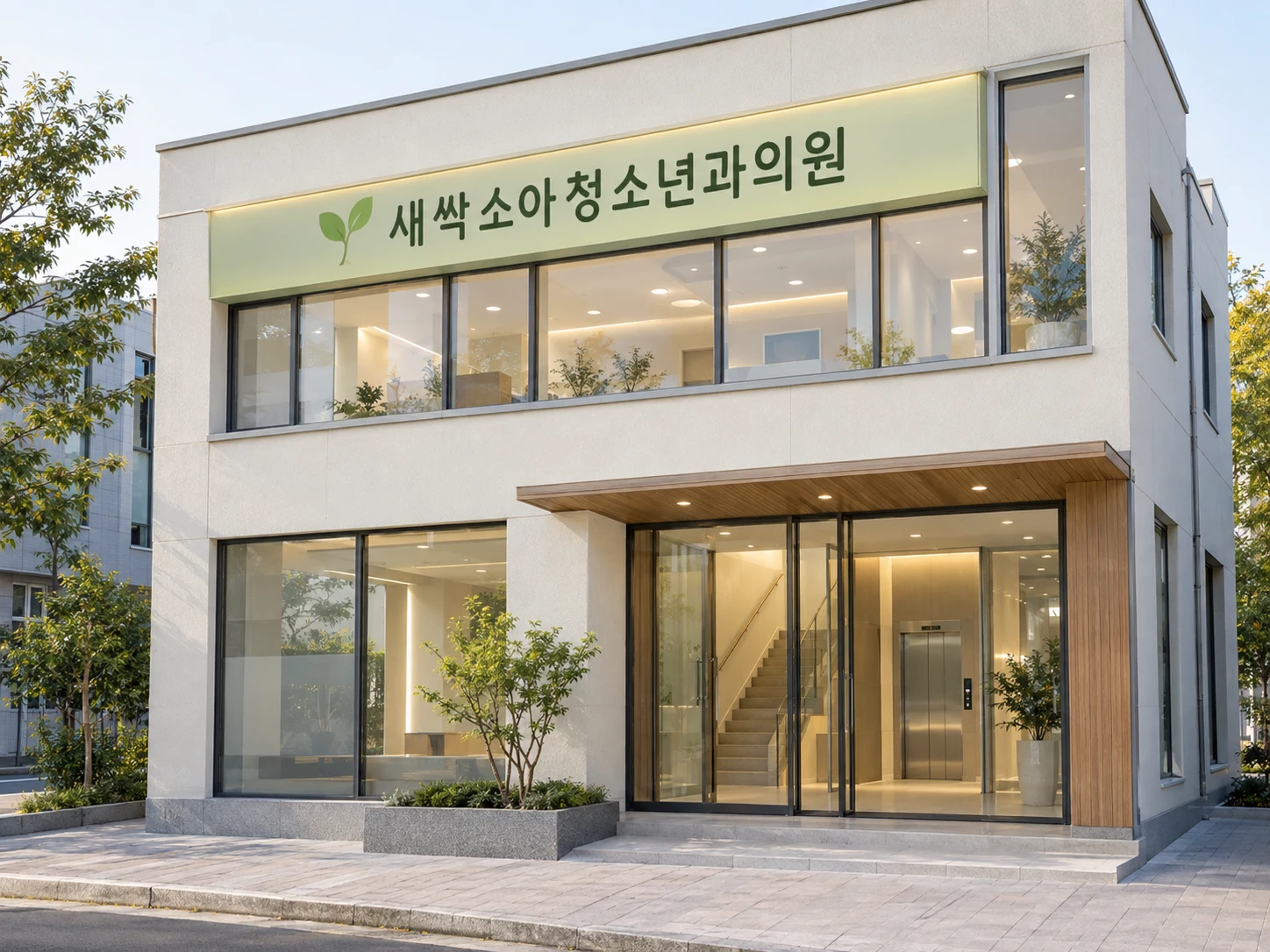 소아과가 있는 2층 건물 외관과 계단 옆 엘리베이터 입구, 연두색 간판이 보이는 사진